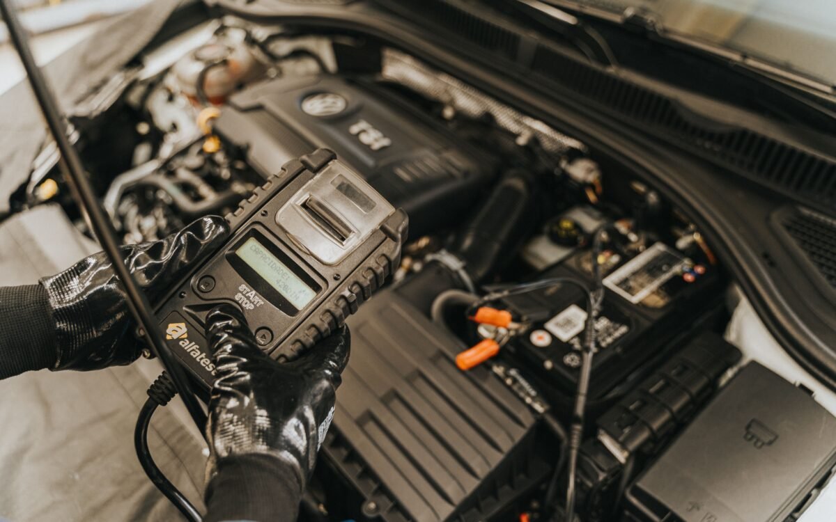 Mechanik podczas chiptuningu wykonujący modyfikację oprogramowania ECU w silniku samochodu