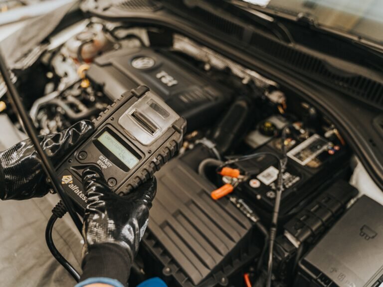 Mechanik podczas chiptuningu wykonujący modyfikację oprogramowania ECU w silniku samochodu