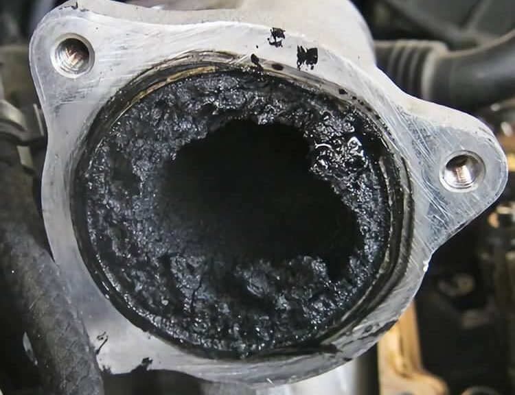 Mechanik podczas usuwania DPF z układu wydechowego samochodu diesel w mobilnym serwisie PoweLab